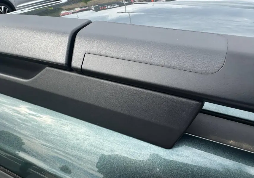 Détail des barres de toit noires sur le toit vert cèdre métallisé d’un Dacia Jogger 2025.
