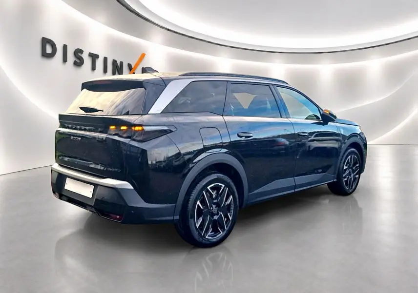 Peugeot 5008 Hybrid 145 GT noir vu en 3/4 arrière droit avec jantes alu et vitres surteintées dans un showroom.