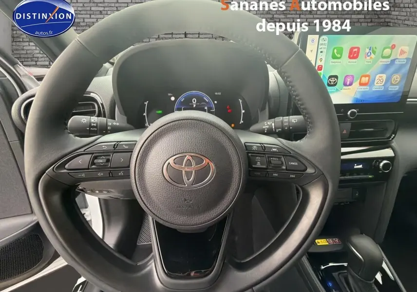 Vue intérieure centrée sur le volant de la Toyota Yaris Cross Hybrid 130h 2025 avec écran tactile et commandes au volant.
