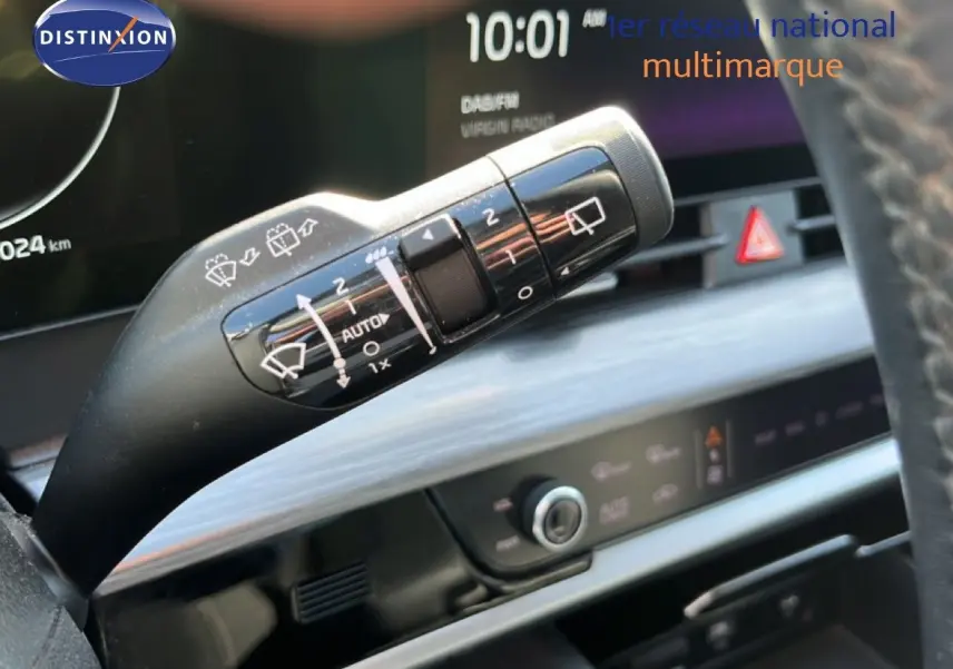 Gros plan sur la commande d’essuie-glace du Kia Sportage bleu fusion métal, avec tableau de bord numérique en arrière-plan.