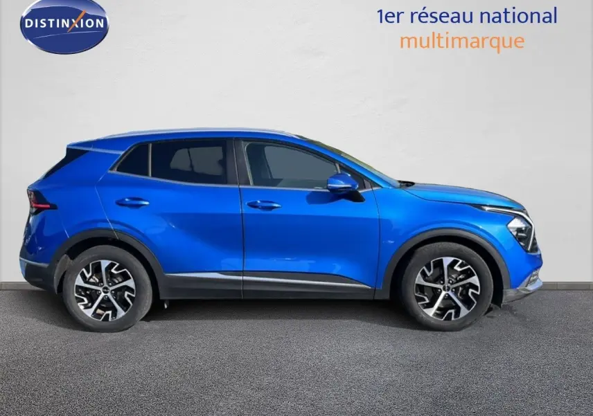 Vue latérale côté gauche d'un KIA Sportage bleu fusion métal 2022 avec jantes alliage et lignes dynamiques.