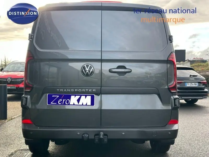 Vue arrière d’un Volkswagen Transporter FGN gris 2025 avec portes battantes et logo VW bien visible.