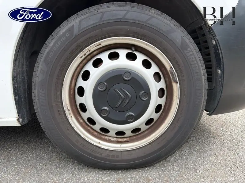 Gros plan sur la roue avant gauche blanche Banquise d'un Citroën Jumpy XS 2021 avec jante acier et logo Citroën central.