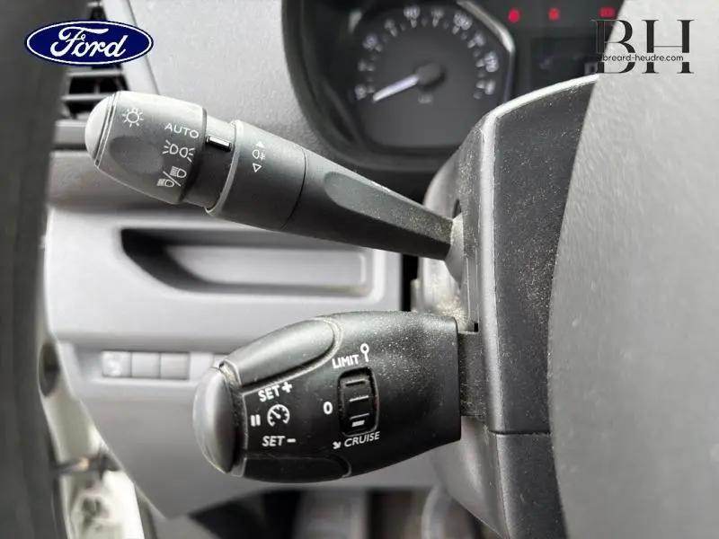 Gros plan sur les commandes de régulateur de vitesse et feux au volant d'un Citroën Jumpy blanc banquise, version 2021.