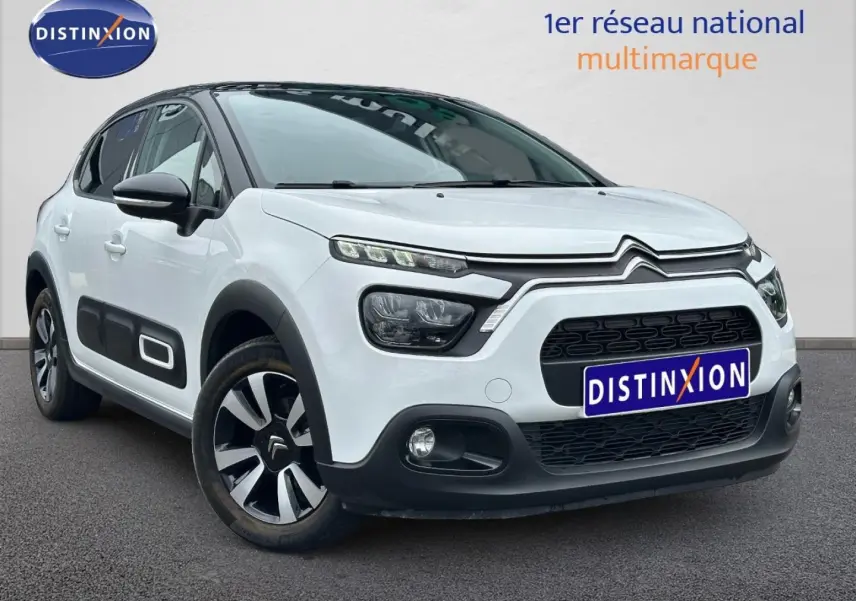 Citroën C3 blanc Banquise vue 3/4 avant droit avec protections latérales noires et jantes alu bicolores.
