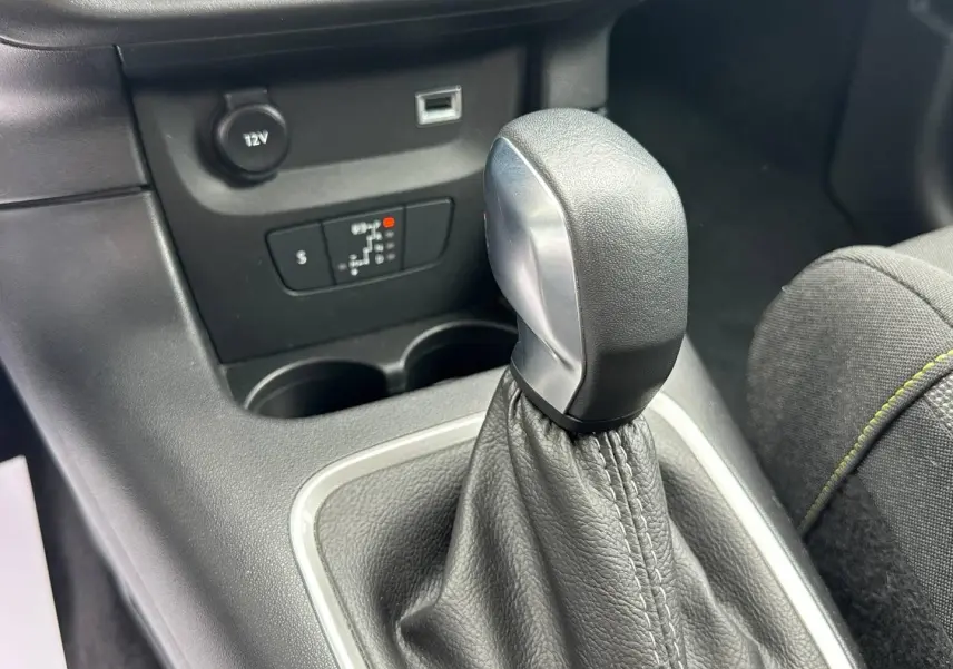 Gros plan sur le pommeau de levier de vitesse cuir noir et console centrale grise de la Citroën C3 2023.