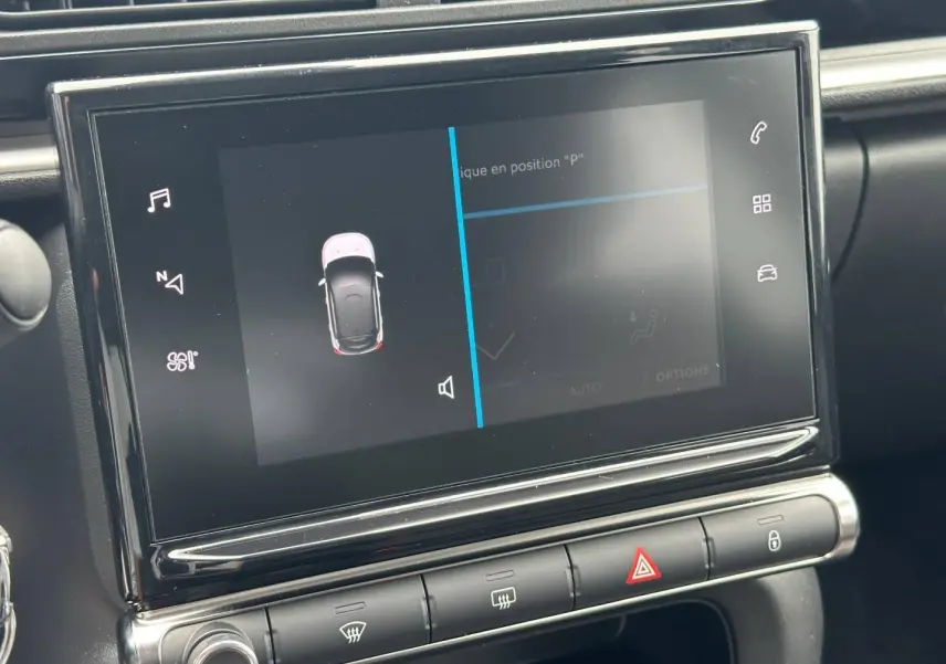 Vue rapprochée de l'écran tactile central et des commandes de la Citroën C3 blanche, affichant l'aide au stationnement.