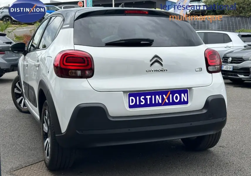 Vue 3/4 arrière droite d'une Citroën C3 2023 blanc banquise avec feux arrière LED et jantes alu noires.