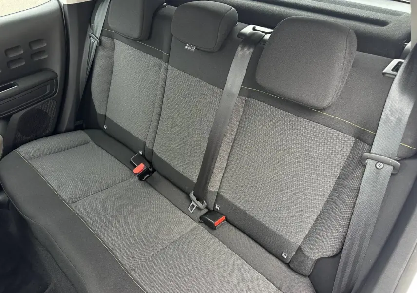 Vue intérieure de la banquette arrière en tissu gris avec ceintures de sécurité de la Citroën C3 Blanc Banquise 2023.