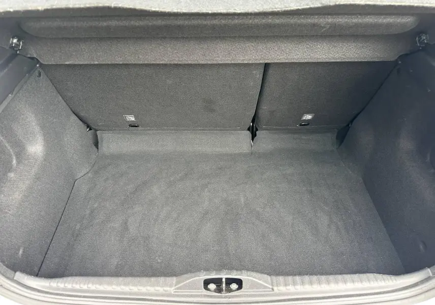 Coffre vide de Citroën C3 blanc Banquise, vue intérieure arrière avec banquette rabattable en tissu gris.