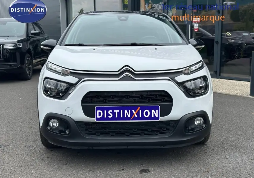 Vue avant d'une Citroën C3 blanche Banquise avec calandre noire et phares LED distinctifs sur un parking.