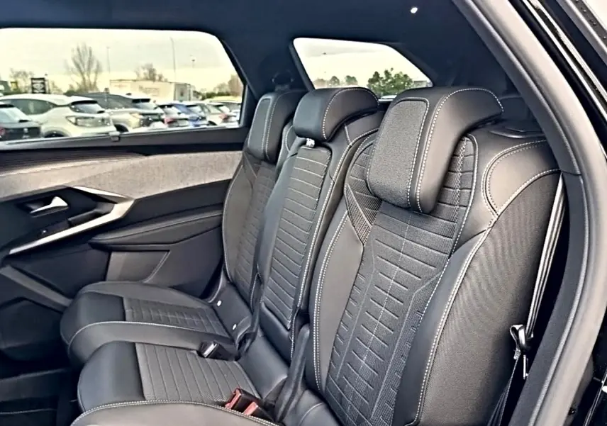 Vue intérieure côté droit sur les sièges arrière noirs en tissu et cuir du Peugeot 5008 Hybrid 145 GT e-dcs6 2026.