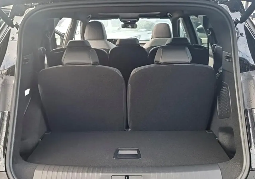 Vue arrière du coffre ouvert du Peugeot 5008 noir, montrant les sièges arrière en position relevée.
