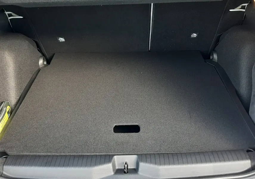Coffre ouvert vu de l'arrière d'une Citroën C3 Aircross 1.2 Hybrid 145ch blanc avec toit noir, intérieur de coffre noir.