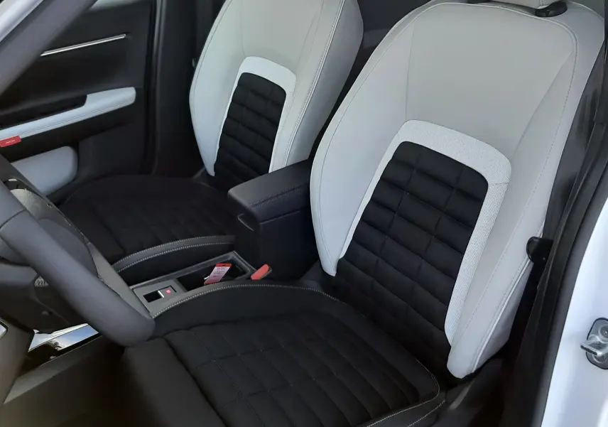 Vue intérieure des sièges avant bicolores noir et blanc du Citroën C3 Aircross 2026, avec accoudoir central.