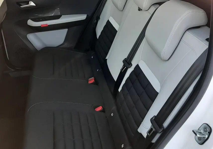 Vue côté gauche des sièges arrière bi-ton noir et blanc du Citroën C3 Aircross 2026 avec porte ouverte.
