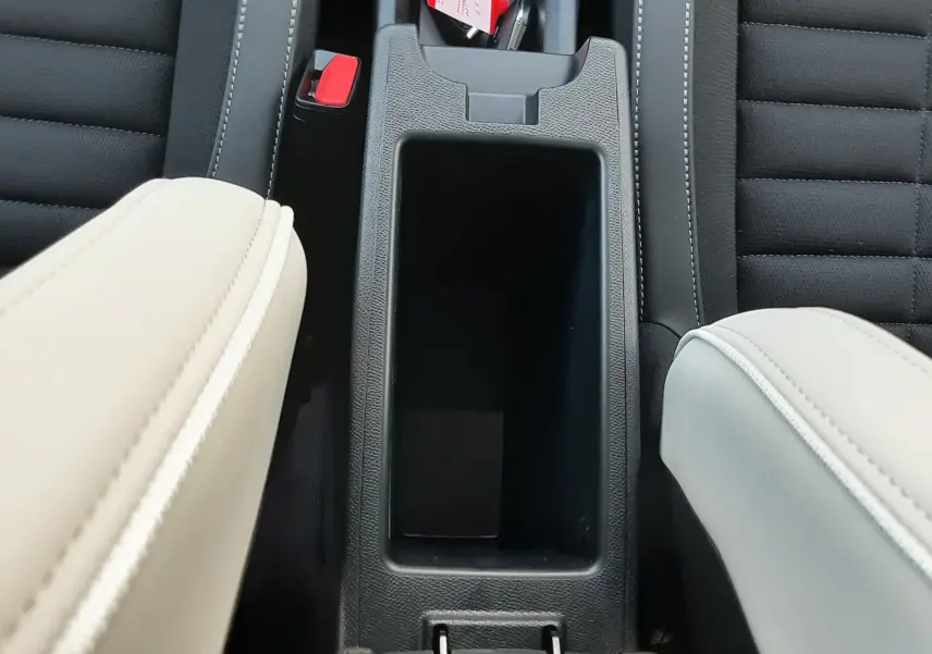 Vue plongeante sur la console centrale noire entre les sièges avant en cuir clair et tissu noir du Citroën C3 Aircross 2026.
