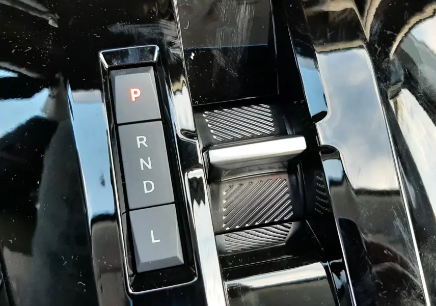 Gros plan sur la commande de boîte automatique noire du Citroën C3 Aircross 1.2 Hybrid 145ch, avec bouton "P" éclairé en rouge.