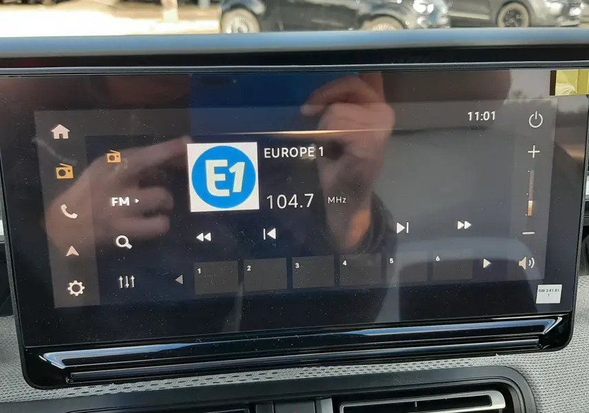 Écran tactile central de la Citroën C3 Aircross 2026 affichant la radio Europe 1 à 104,7 MHz, intérieur noir.