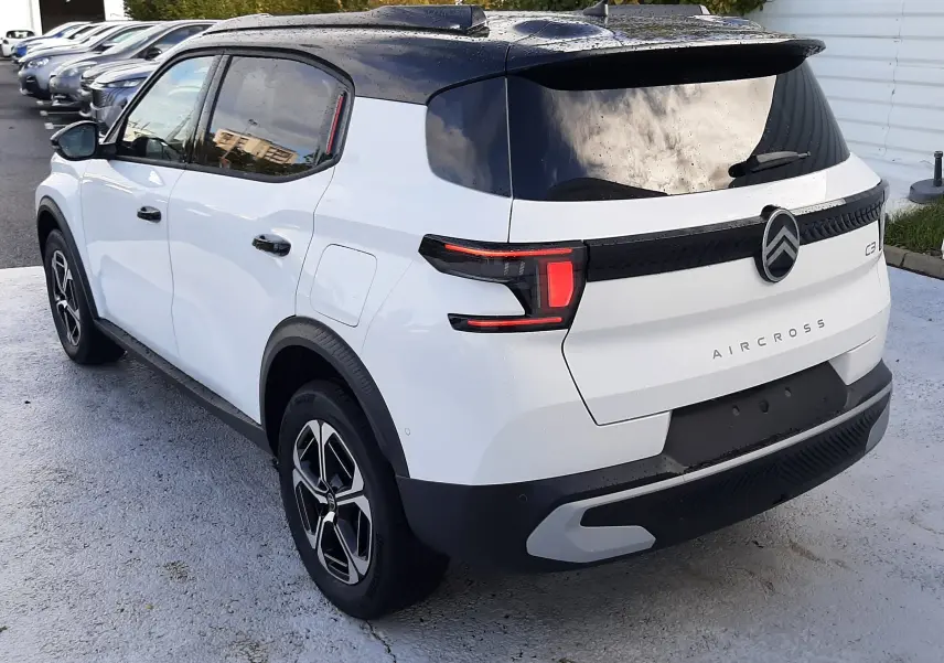 Vue 3/4 arrière droite du Citroën C3 Aircross blanc avec toit noir, feux arrière LED et jantes alliage.