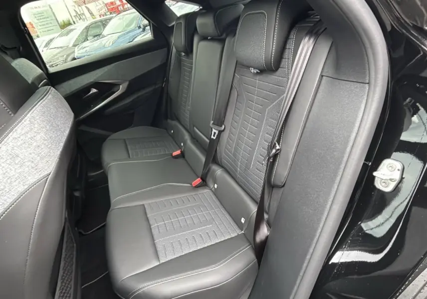 Vue côté droit sur la banquette arrière en cuir et tissu gris d’un Peugeot 3008 2026 avec porte ouverte.