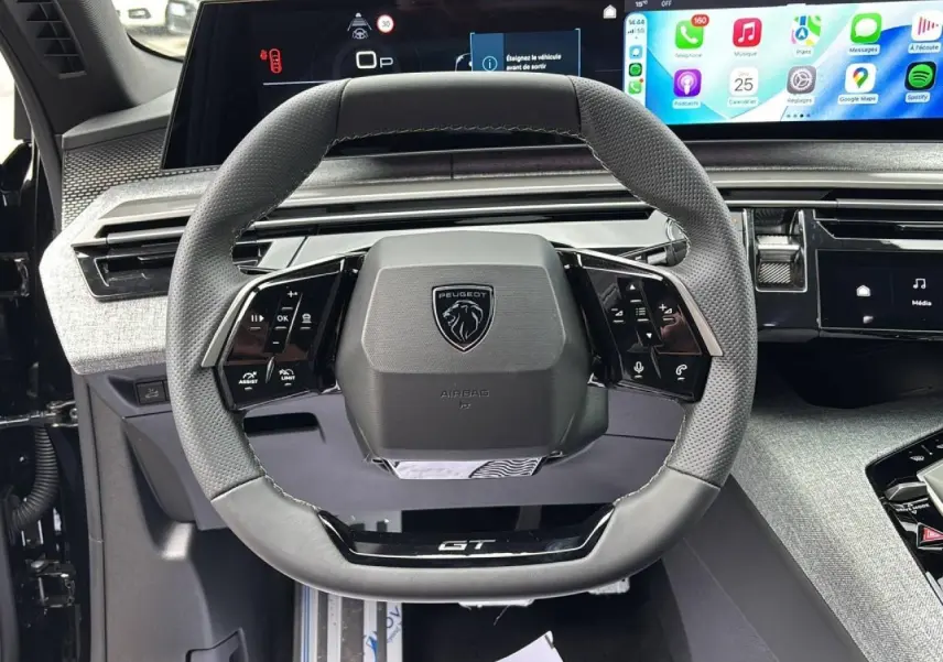 Vue rapprochée du volant cuir perforé gris du Peugeot 3008 GT 2026 avec tableau de bord numérique panoramique et écran tactile.