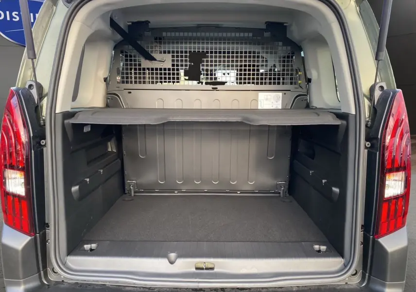 Vue arrière du Peugeot Rifter 1.5 BlueHDi vert Sirkka, coffre ouvert avec cloison métallique de séparation visible.
