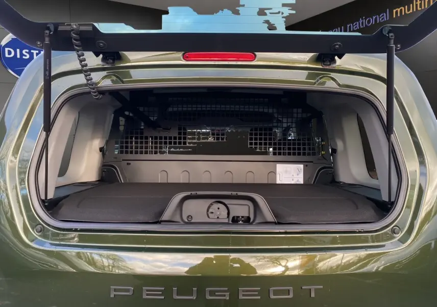 Vue arrière du Peugeot Rifter 2025 vert Sirkka Green avec hayon ouvert et cloison de séparation visible dans le coffre.