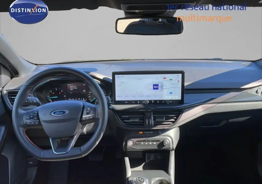 Vue frontale de l’habitacle de la Ford Focus SW noire, avec tableau de bord numérique et grand écran tactile central.