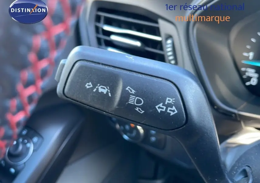 Gros plan sur la commande de clignotants et aides à la conduite dans l’habitacle noir d’une Ford Focus SW 2024.