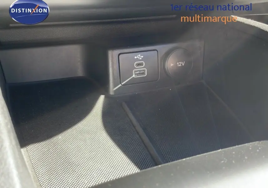 Prise USB et prise 12V en gros plan dans l’habitacle noir de la Ford Focus SW 1.5 EcoBlue 2024.
