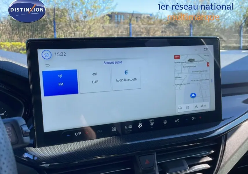 Vue intérieure du tableau de bord de la Ford Focus SW 2024 noir agate, avec écran tactile central affichant les sources audio et la navigation.
