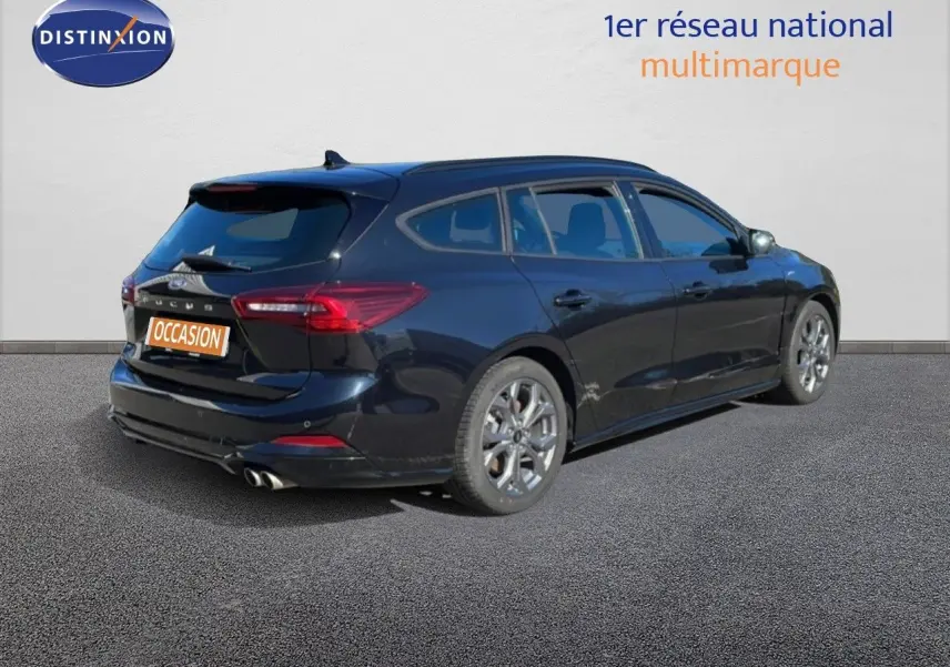 Vue 3/4 arrière droite d’une Ford Focus SW noire Agate Metal, avec jantes alliage et double sortie d’échappement.