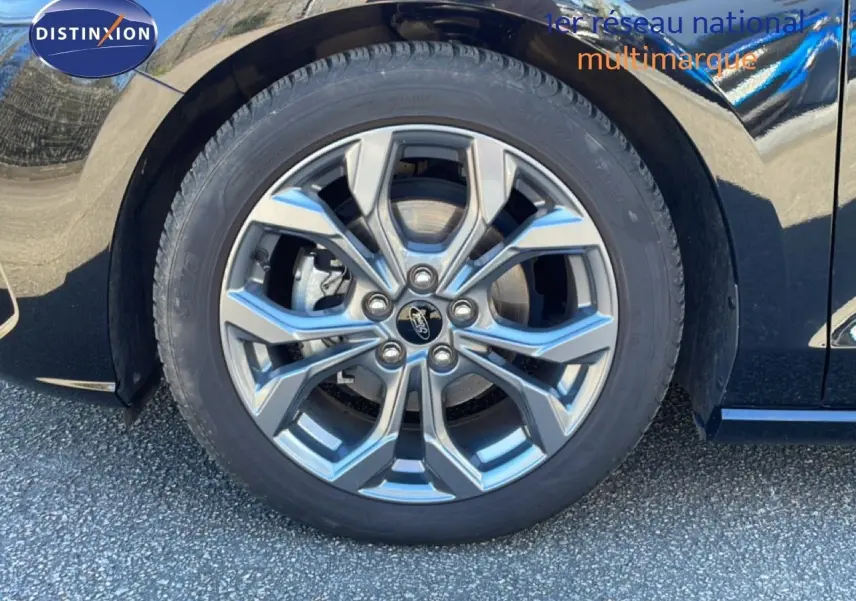 Gros plan sur la roue avant droite de la Ford Focus SW noire, mettant en valeur la jante alliage au design moderne.