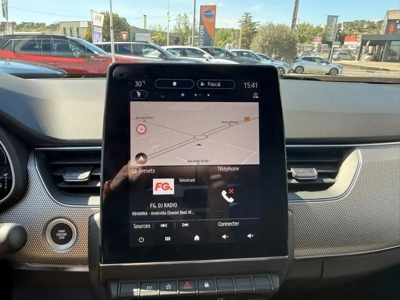 Vue intérieure centrée sur l’écran tactile du tableau de bord du Renault Arkana 2022, avec navigation et radio affichées.