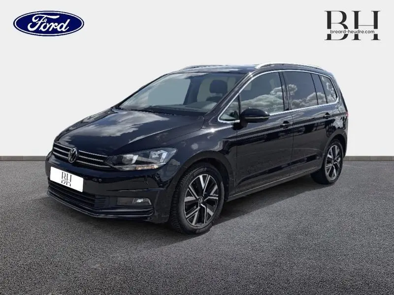 Volkswagen Touran noir intense nacré en vue 3/4 avant droit, avec jantes alliage et vitres teintées.