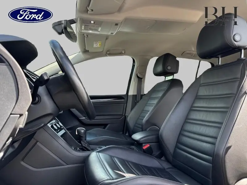 Vue intérieure côté conducteur du Volkswagen Touran 2.0 TDI 2020, sièges cuir noir Vienna et volant cuir multifonction.
