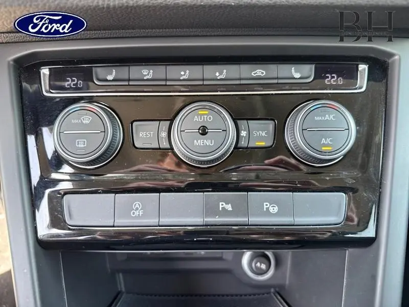Détail de la console centrale du Volkswagen Touran noir, avec commandes de climatisation automatique et boutons de fonctions assistées.