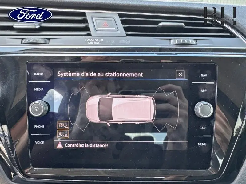 Écran tactile intérieur montrant le système d'aide au stationnement du Volkswagen Touran noir intense nacré.