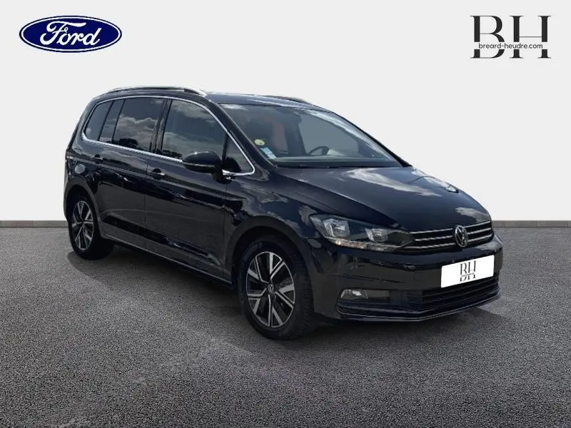 Volkswagen Touran noir intense nacré en 3/4 avant droit, avec jantes alliage et vitres teintées.