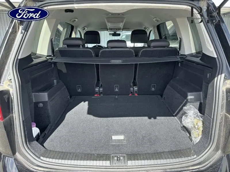 Coffre ouvert d’un SUV noir vu de l’arrière, montrant un espace de chargement spacieux avec banquette arrière en tissu noir.