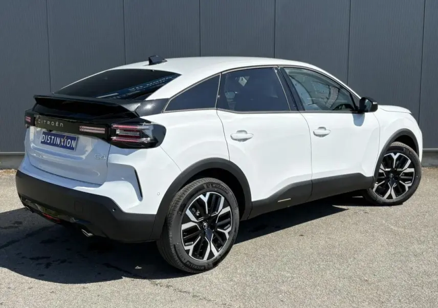 Vue 3/4 arrière droite d'une Citroën C4 blanche Okenite avec toit noir et jantes bicolores 18 pouces.