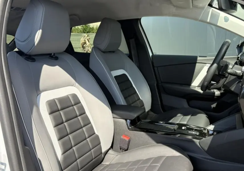 Vue intérieure côté droit montrant les sièges avant bi-ton gris clair et foncé du Citroën C4 Hybrid 2025.