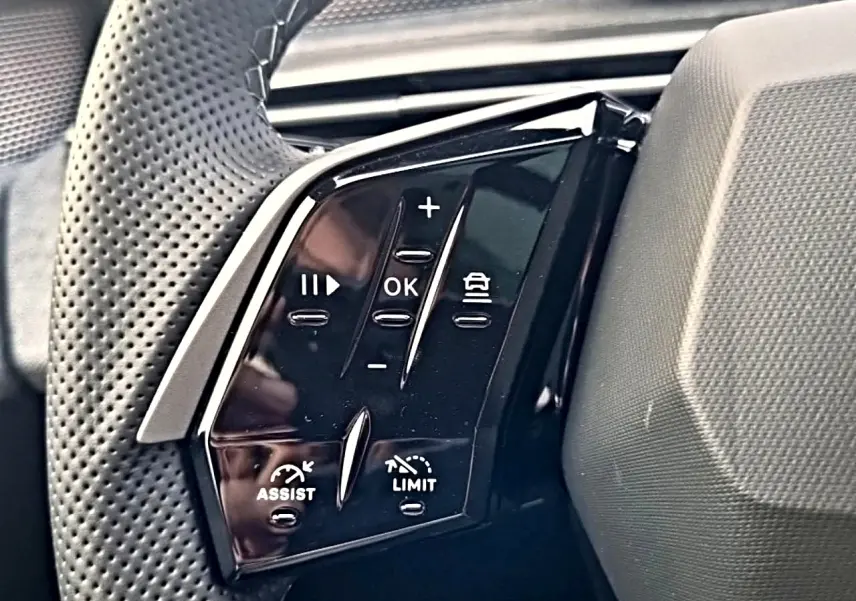Gros plan sur les commandes noires multifonctions au volant cuir perforé du Peugeot 5008 Hybrid 145 GT e-dcs6.