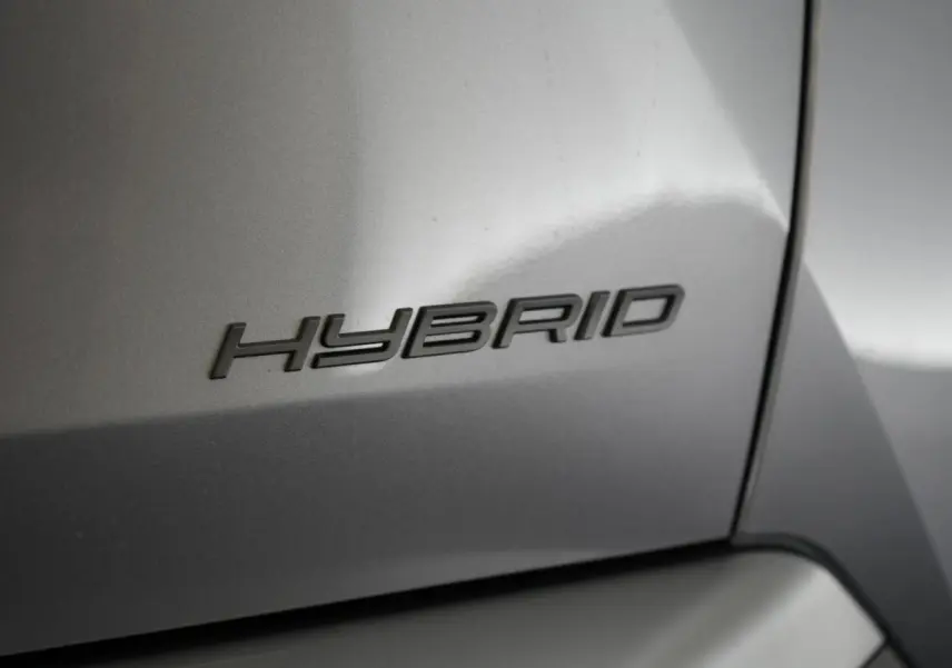Gros plan sur l’inscription « Hybrid » en relief sur la carrosserie gris Artense d’un Peugeot 3008.