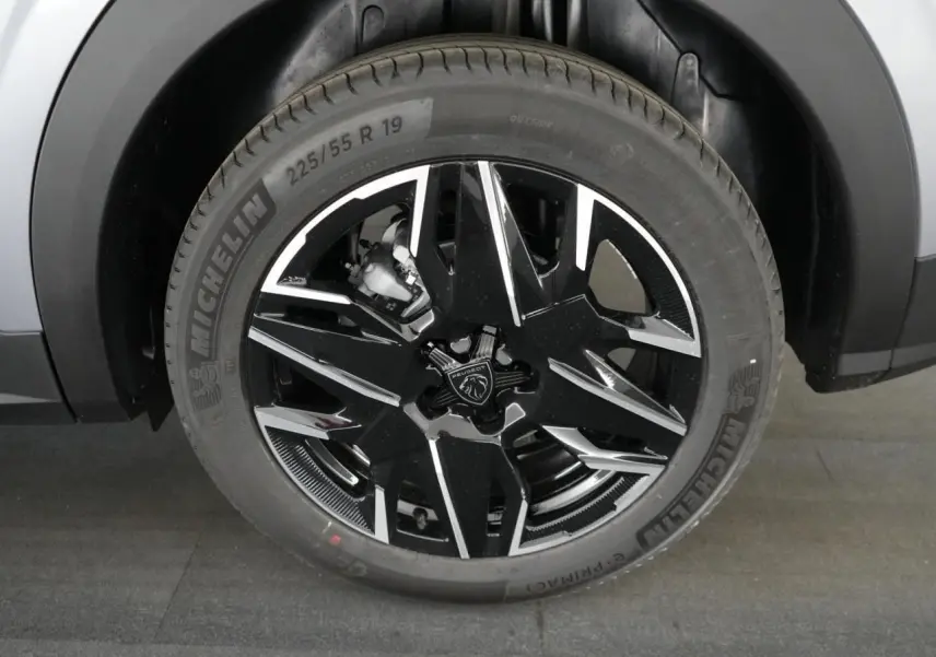 Gros plan sur la jante alliage noire et argentée de 19 pouces du Peugeot 3008 gris Artense, roue avant droite.