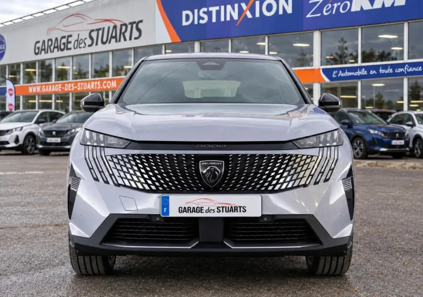 Vue avant d'un Peugeot 3008 gris Artense avec calandre noire à motif géométrique et phares LED fins, sur parking de concession.