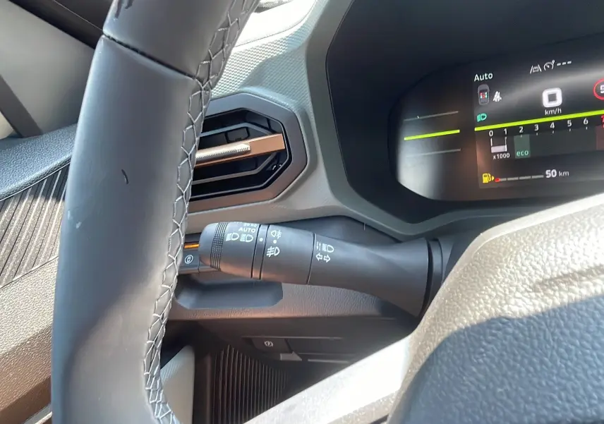 Vue rapprochée du tableau de bord du Dacia Duster 2025, avec volant et affichage numérique moderne.