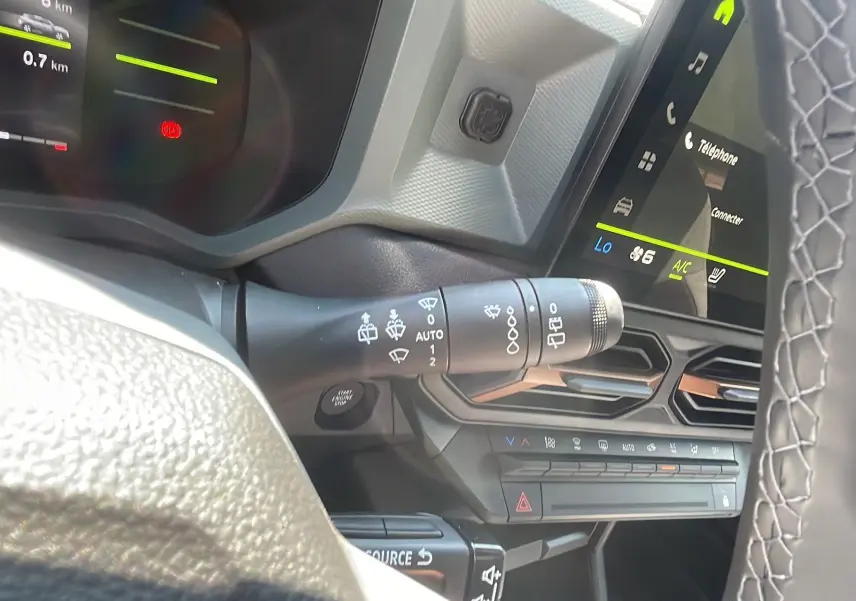 Détail du commodo d'essuie-glace et tableau de bord numérique du Dacia Duster 2025 vert cèdre, version Extreme Plus.