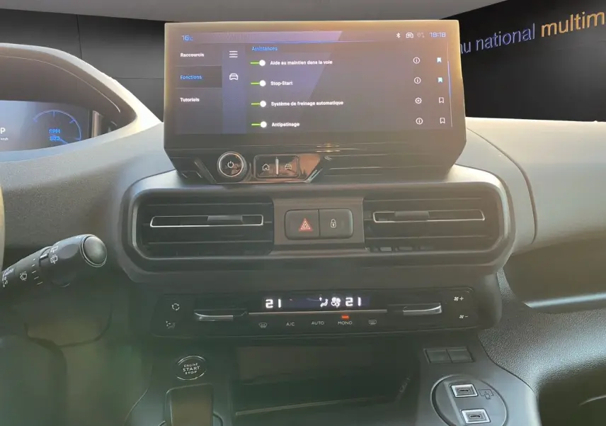 Vue intérieure du tableau de bord du Peugeot Rifter gris acier 2025, avec écran tactile et commandes climatisation.